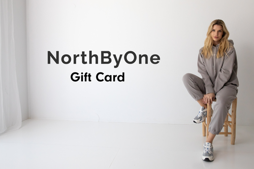 Woman in a gray tracksuit sitting on a stool with 'NorthByOne' Gift Card text overlay