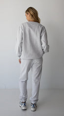 Woman wearing the NorthByOne Emma Baggy Sweat Pant in Marle Grey, with elasticated ankle and waistband standing against a plain background