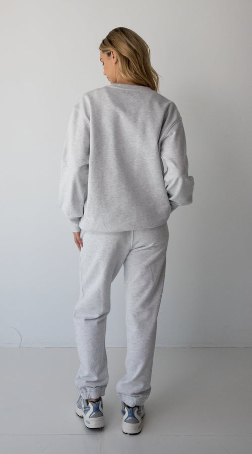 Woman wearing the NorthByOne Emma Baggy Sweat Pant in Marle Grey, with elasticated ankle and waistband standing against a plain background