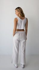 Woman wearing NorthByOne Sadie Linen Pant in white with elastic waistband and side pockets standing against a plain background