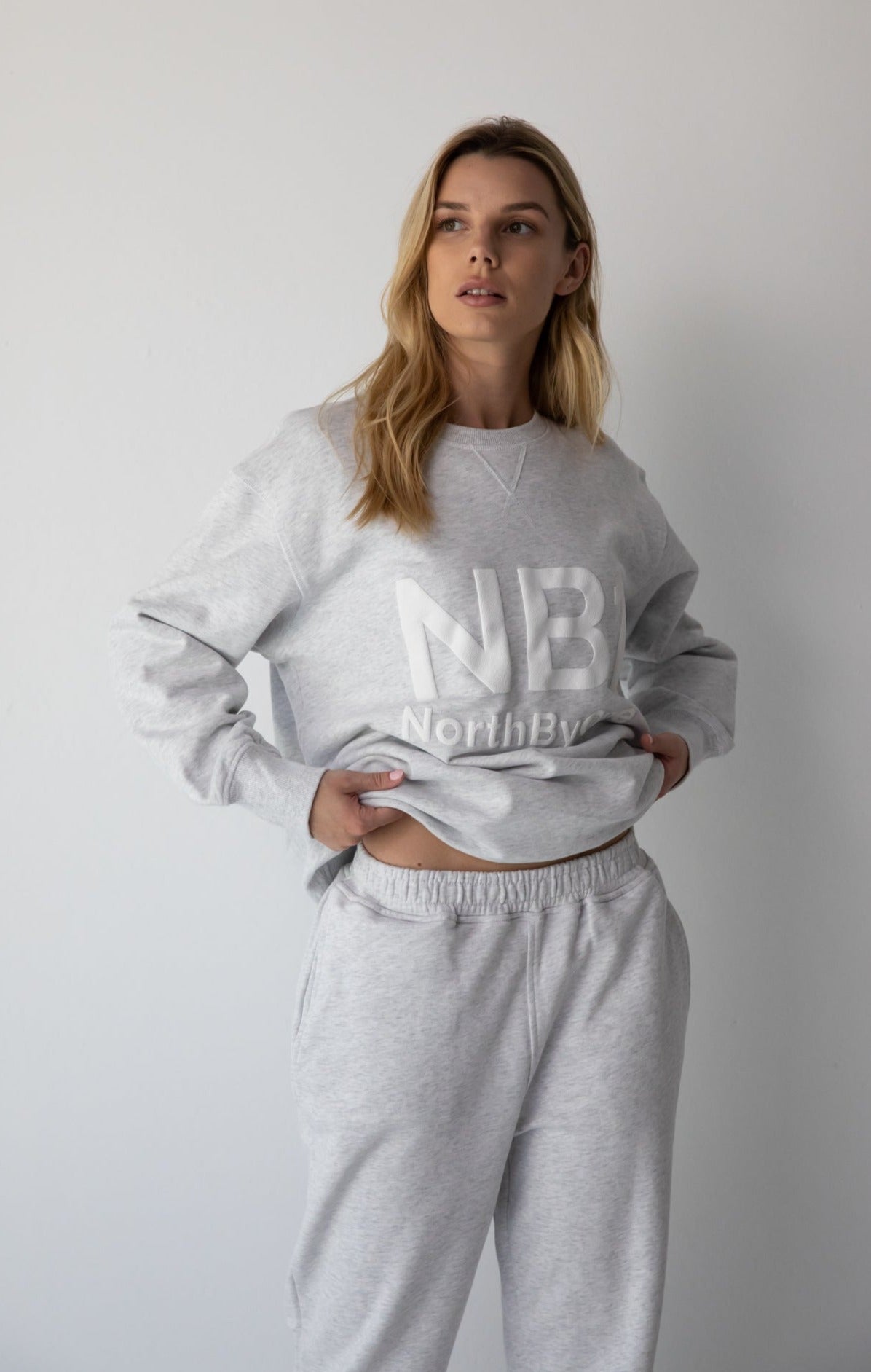 Woman wearing the NorthByOne Emma Baggy Sweat Pant in Marle Grey, with matching sweatshirt against a plain white background