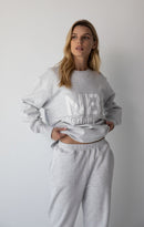 Woman wearing the NorthByOne Emma Baggy Sweat Pant in Marle Grey, with matching sweatshirt against a plain white background