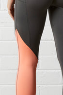 Close-up of the NorthByOn Cara Three Quarter Tight - Slate Grey / Neon Pink against white brick wall background